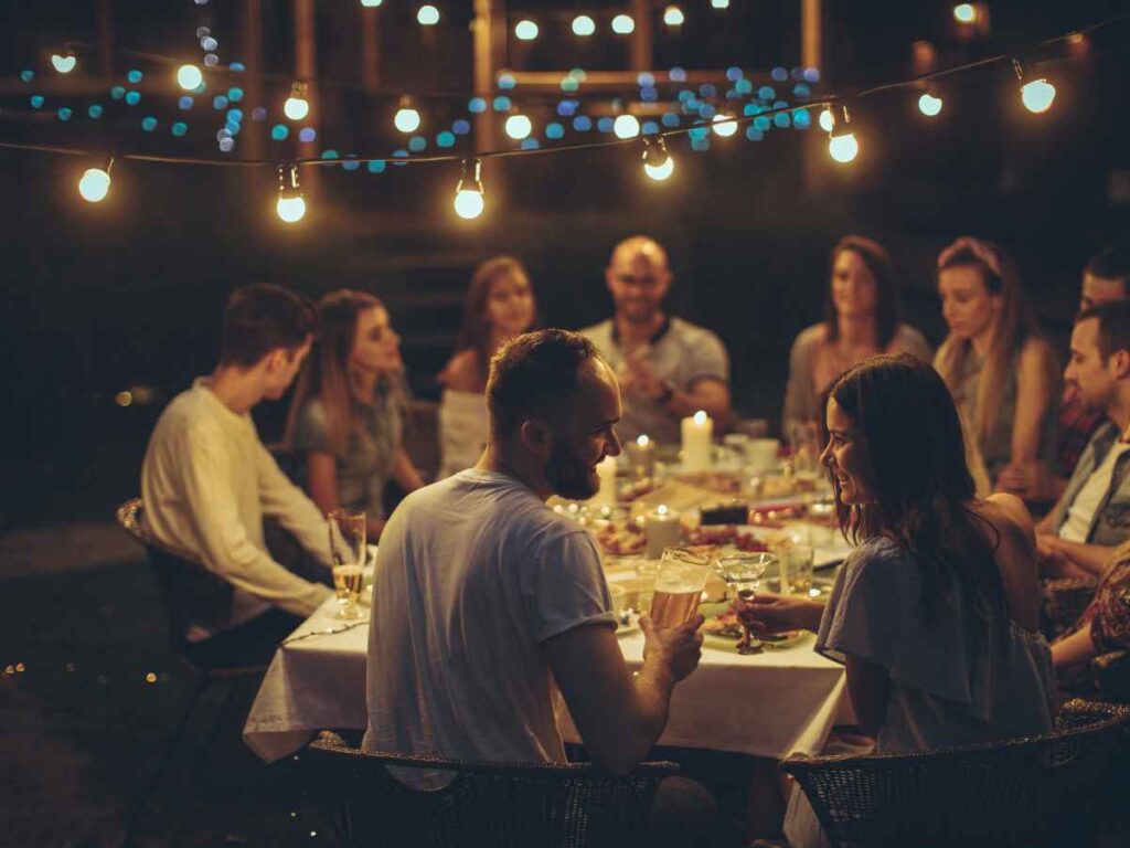 Two older Italian men embracing at a family dinner, representing the traditional compare bond